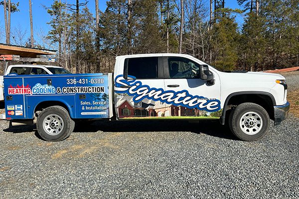 truck-2 truck in a driveway with company branded graphics on it