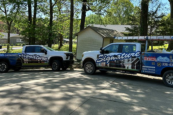 two-trucks two trucks in a driveway with company branded graphics on them
